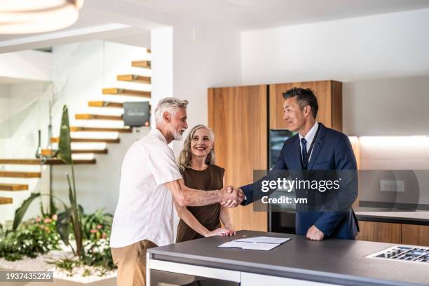 couple signing house leasing agreement - open house stock pictures, royalty-free photos & images