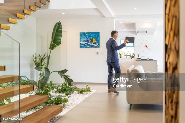 real estate agent showing interior using tablet - real estate fotografías e imágenes de stock