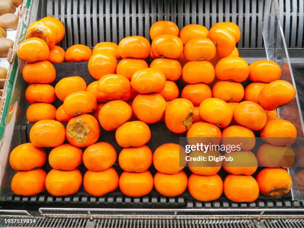 persimmon fruits at market - raw acrylic stock pictures, royalty-free photos & images