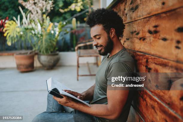 young man reading the bible - religieuze tekst stockfoto's en -beelden