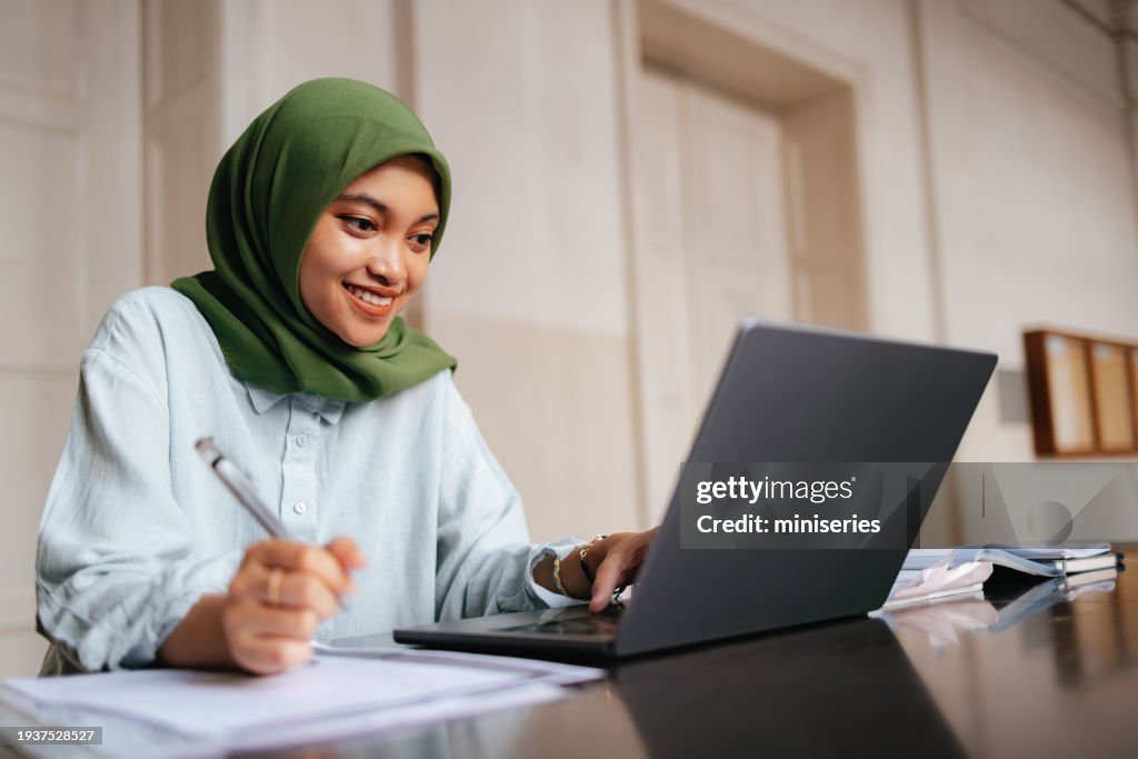 Portrait of a Beautiful Female Indonesian Student Using a Laptop Computer
