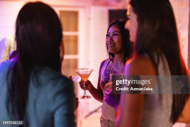 small female friends group hanging out at an evening cocktail party - summer cocktails garden party drinks bildbanksfoton och bilder