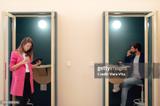 couple of business people working with technology at private coworking booth - booth stock pictures, royalty-free photos & images