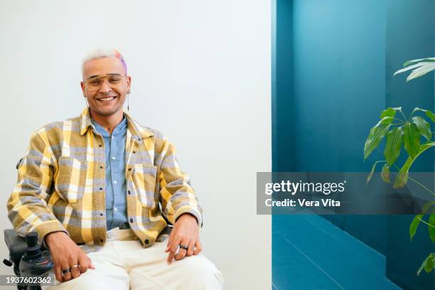 portrait of mixed race man with street style sit on wheelchair at white background - visual impairment - fotografias e filmes do acervo