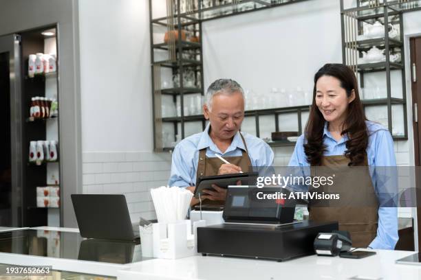 se revela la propiedad de una cafetería: el viaje de control de calidad y satisfacción del cliente de una pareja de personas mayores - flujo de caja fotografías e imágenes de stock