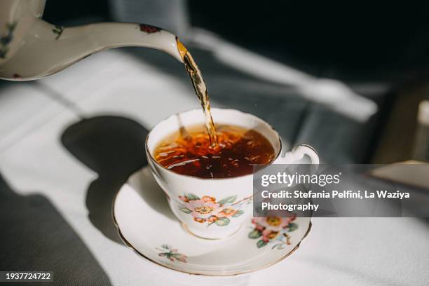 vintage china pouring tea in tea pot - poured stock pictures, royalty-free photos & images