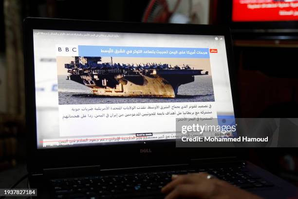 Yemeni man browsing the news on his laptop screen that broadcasts U.S. Warship amid news spread relating to the attack on the Zografia ship in the...