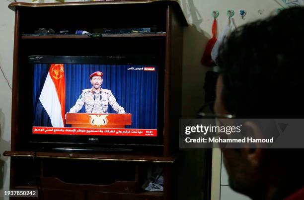 Yemeni man watches a broadcast speech of Yemen's Houthi Military spokesperson brigader Yahya Sarea on TV relating to the attack on the Zografia ship...