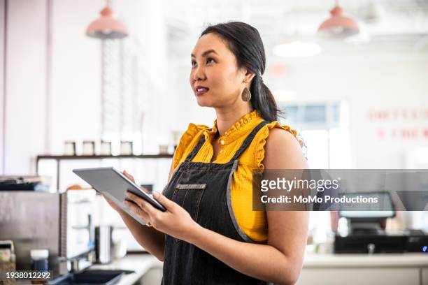 female coffeeshop owner taking inventory with digital tablet - small business owners stock pictures, royalty-free photos & images