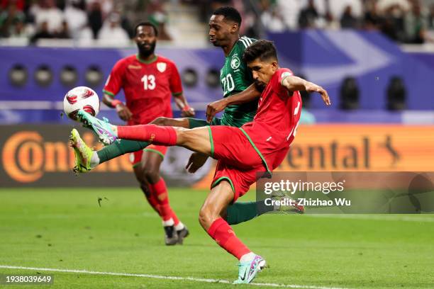 Ahmed Al Kaabi of Oman competes for the ball with Abdullah Radif of Saudi Arabia during the AFC Asian Cup Group F match between Saudi Arabia and Oman...