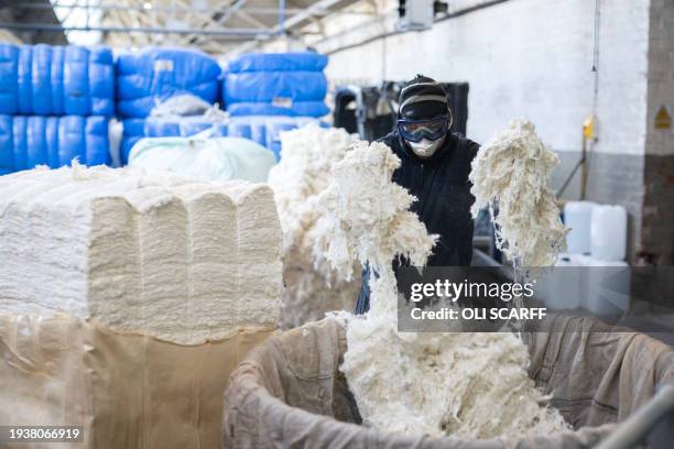 An employee at Mallalieus' mill weighs out raw woollen fibres to be dyed, in Delph, near Oldham, northern England on January 17, 2024. Founded in...