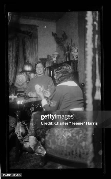 View of Ada Harris and Mary Louise Harris as they play a card game at a table in a home, Pittsburgh, Pennsylvania, ca 1930