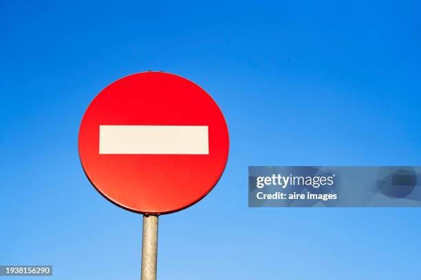 metal pole with a round sign of a red traffic signal with a white line on the street, front view with low angle. - speed limits by country photos et images de collection