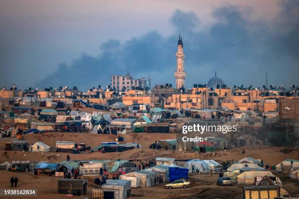 Picture taken from a makeshift camp for displaced Palestinians on the west of Rafah near the Egyptian border shows smoke billowing in Khan Yunis...