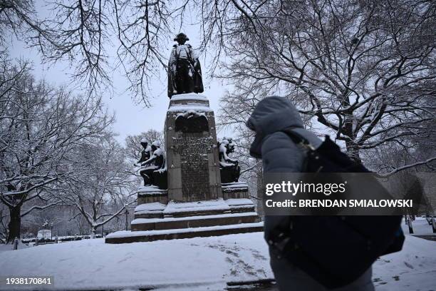 The memorial statue of Baron Friedrich Wilhelm von Steuben is covered in snow at Lafayette Square during a storm, in Washington, DC, on January 19,...