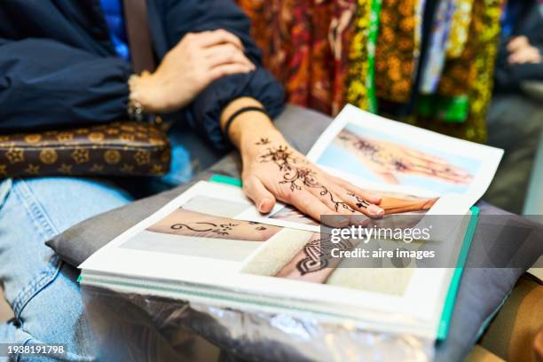 front view of the hand of a beautiful tourist woman showing her moroccan tattoo on a cushion - temporary stock pictures, royalty-free photos & images