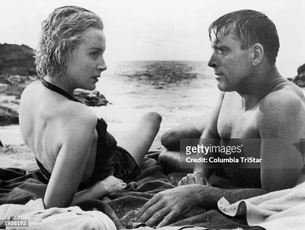 Scottish-born actor Deborah Kerr and American actor Burt Lancaster lay on the beach in a still from the film 'From Here to Eternity,' directed by...