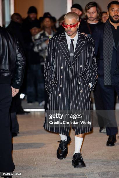 Rauw Alejandro is seen wearing black striped coat, tie outside Louis Vuitton during the Menswear Fall/Winter 2024/2025 as part of Paris Fashion Week...