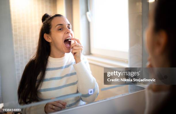 woman sprays the spray down her throat - sprinkles stock pictures, royalty-free photos & images