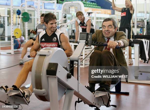 British actor and comedian Rowan Atkinson , in character as "Mr Bean", competes with footballer Brodie Holland on a rowing machine as he visits the...