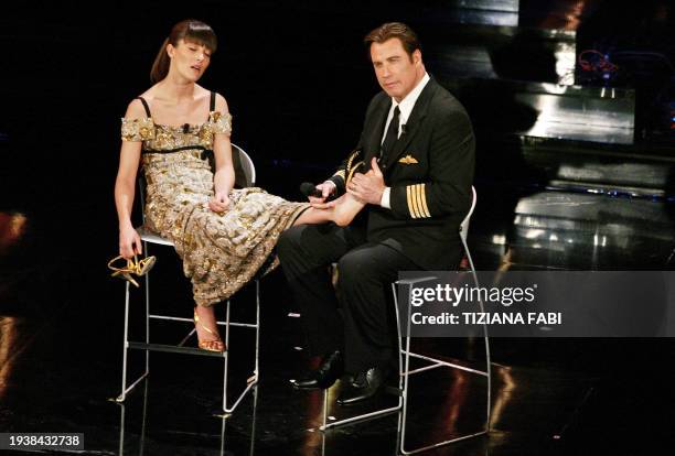 Actor John Travolta makes a foot massage to Italian showgirl Vittoria Cabello on the stage of the Ariston Theatre during the 56th Italian music...