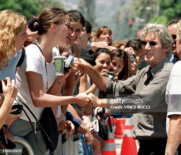 Actor Richard Gere shakes hands with fans after he placing his hands and feet in cement during ceremony at Mann's Chinese Theatre 26 July 1999 in...