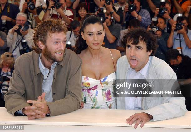 French actor Albert Dupontel grimaces as he poses for photographers with Italian actress Monica Bellucci and French actor Vincent Cassel during a...