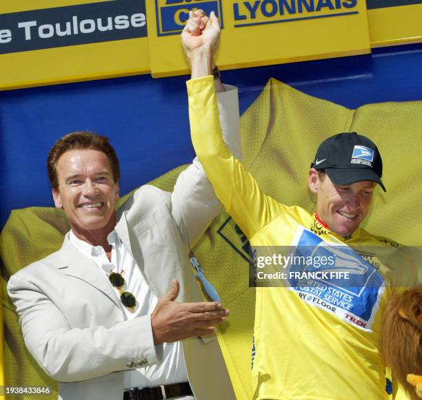 Lance Armstrong and his compatriot actor Arnold Schwarzenegger celebrate on the podium at the end of the 11th stage of the 90th Tour de France...