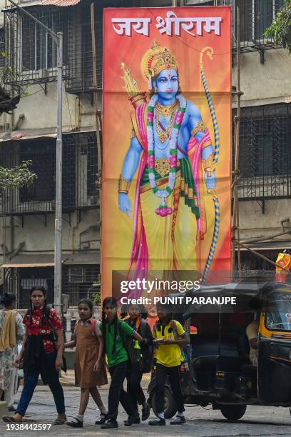 Commuters move past a billboard displaying Hindu god Ram at a junction in Mumbai on January 20 ahead of the consecration ceremony of a temple of...