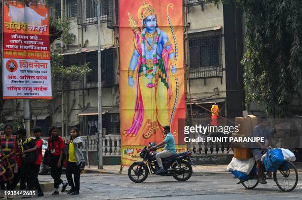 Commuters move past a billboard displaying Hindu god Ram at a junction in Mumbai on January 20 ahead of the consecration ceremony of a temple of...