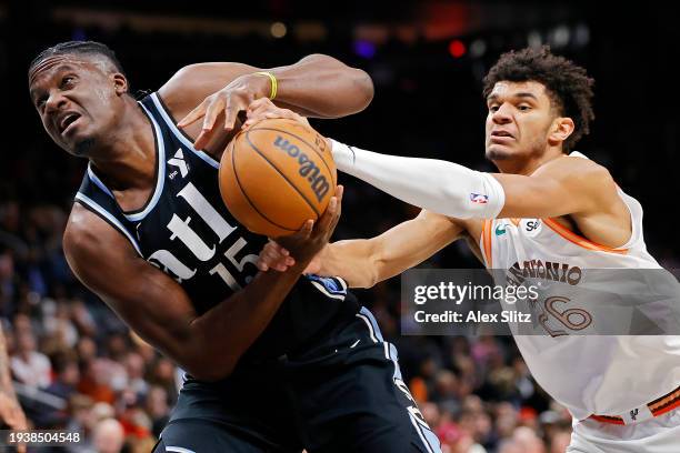 Clint Capela of the Atlanta Hawks draws a foul from Dominick Barlow of the San Antonio Spurs during the first half at State Farm Arena on January 15,...