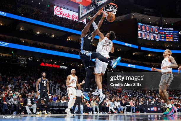 Clint Capela of the Atlanta Hawks slam dunks the ball over Dominick Barlow of the San Antonio Spurs during the first half at State Farm Arena on...