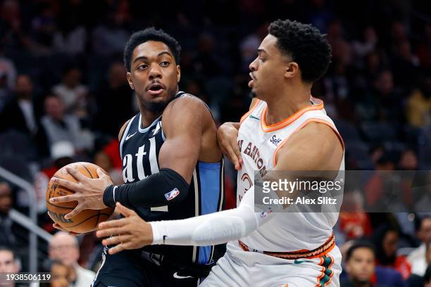 Trent Forrest of the Atlanta Hawks works against Keldon Johnson of the San Antonio Spurs during the first half at State Farm Arena on January 15,...