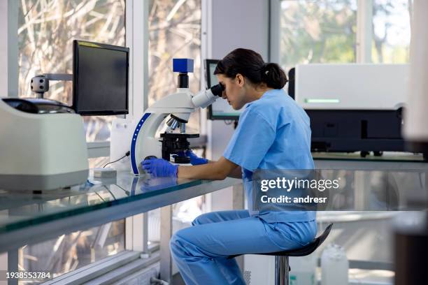 investigador de la salud que trabaja en el laboratorio con un microscopio - microbiologist fotografías e imágenes de stock