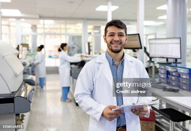 doctor working at a laboratory and holding test results - profissional de primeira linha imagens e fotografias de stock