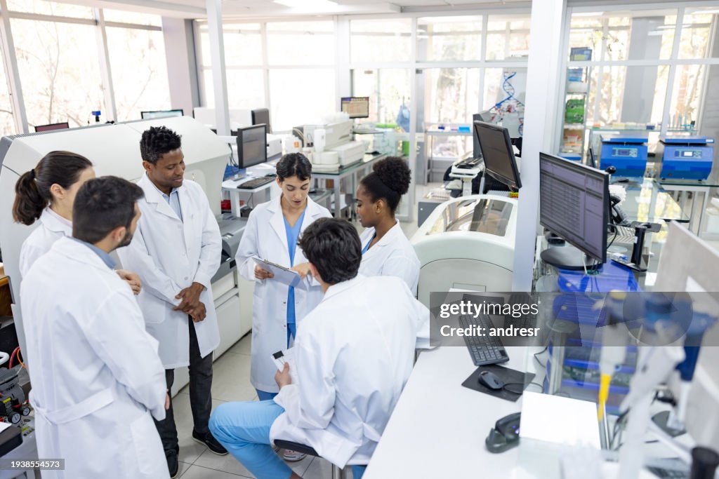 Wissenschaftlerteam im Gespräch bei einer Mitarbeiterversammlung im Labor