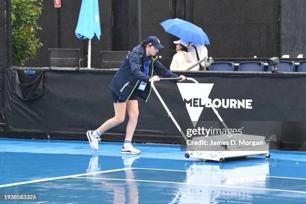 Australian Open staff move machinery to remove water onto an outside court after heavy rain has delayed play during the 2024 Australian Open at...