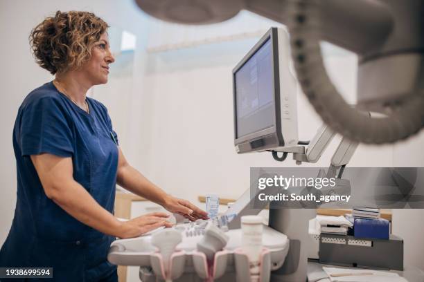 female doctor working on ultrasound scanning machine - ultraljud bildbanksfoton och bilder