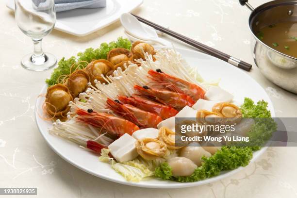 chinese luxury steamboat with shrimp ,abalone and vegetables - fishball stock-fotos und bilder