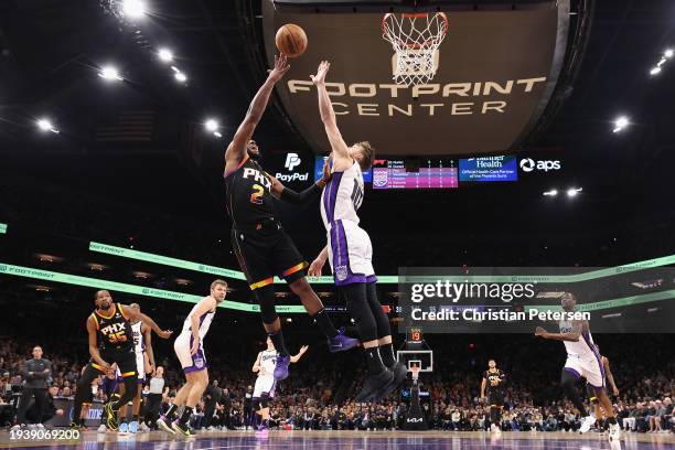 Josh Okogie of the Phoenix Suns puts up a shot over Domantas Sabonis of the Sacramento Kings during the first half of the NBA game at Footprint...