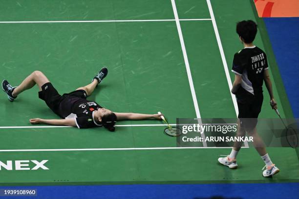 China's Zheng Yu falls on the court as her teammate Zhang Shuxian watches while playing against China's Li Wen Mei and Liu Xuanxuan during their...