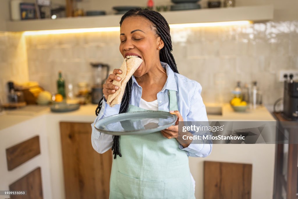 Woman having healthy snack in her kitchen