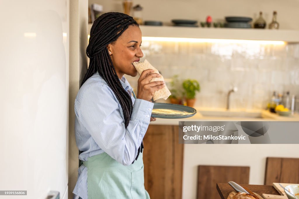 Woman having healthy snack in her kitchen