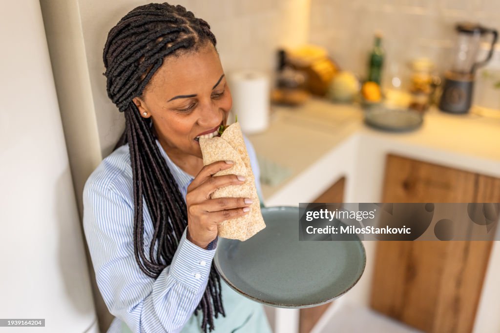 Woman having healthy snack in her kitchen