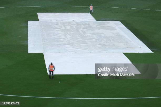 Covers lie on the wicket as rain falls ahead of the BBL match between Sydney Thunder and Melbourne Renegades at GIANTS Stadium, on January 17 in...