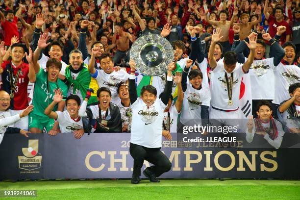 Head coach Masatada Ishii of Kashima Antlers lifts the J.League Champions plaque for fans after the J.League Championship Final second leg match...