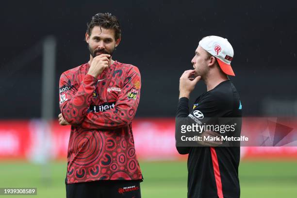 Kane Richardson and Mackenzie Harvey of the Renegades look on as rain delays the start of the BBL match between Sydney Thunder and Melbourne...