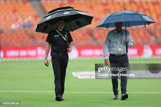 Match officials walk from the field as rain delays the start of the BBL match between Sydney Thunder and Melbourne Renegades at GIANTS Stadium, on...
