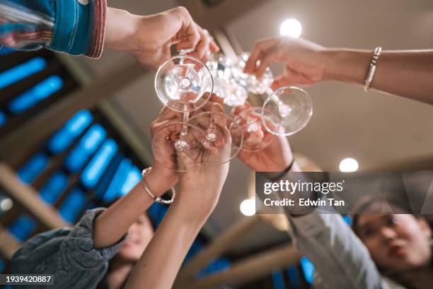 low angle close up cheerful asian chinese friends celebration toasting indoor dining - click below stock pictures, royalty-free photos & images