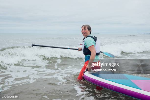 heading out on her paddle board - life jacket photos stock pictures, royalty-free photos & images